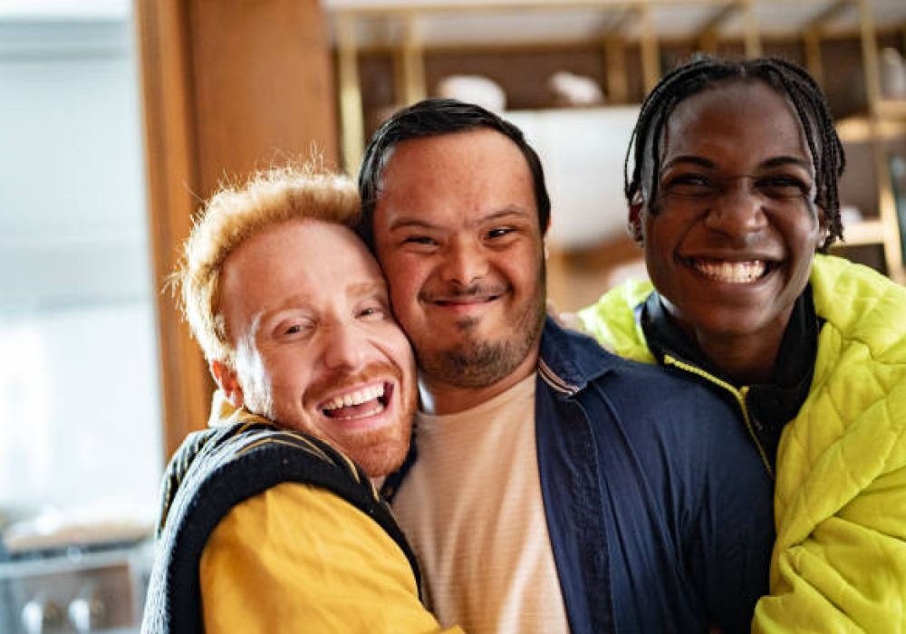 Portrait of a disabled young man and his friends embraced at home