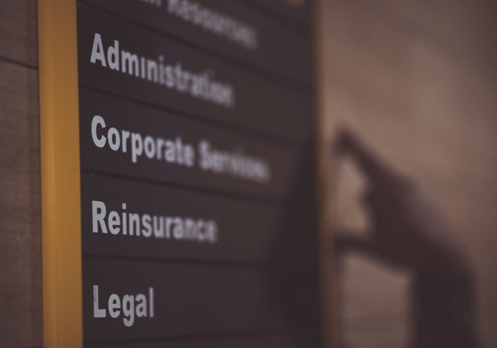 Close-up of an office directory sign showing administration and legal departments.