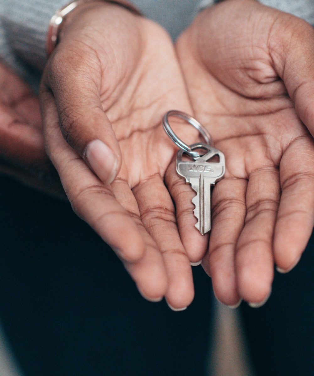 Close-up of hands holding a key, symbolizing homeownership, real estate, and property investment.